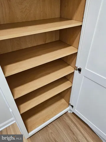 a view of room with wooden floor and cabinet