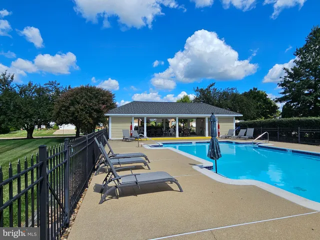 a view of a house with pool and chairs
