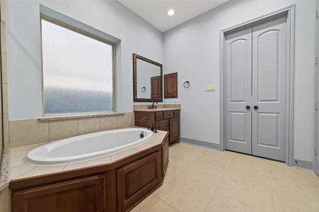 a bathroom with a granite countertop double vanity sink and a mirror