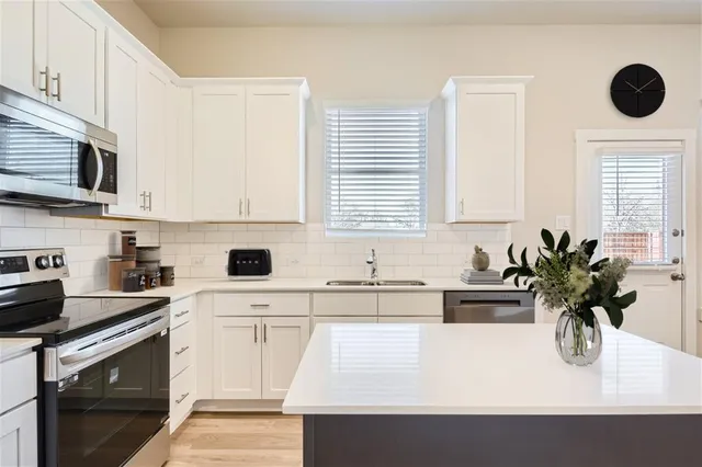 a kitchen with a sink a white cabinets and white appliances