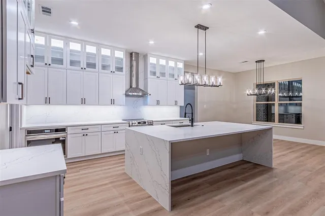 a large kitchen with kitchen island a sink stainless steel appliances and cabinets