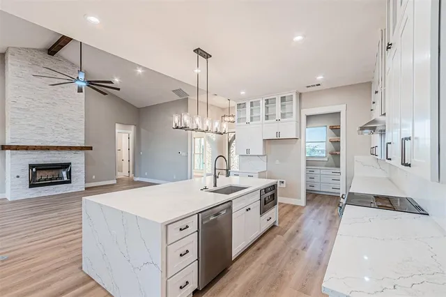 a large kitchen with stainless steel appliances granite countertop a lot of counter space and wooden floor