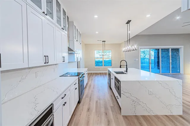 a large kitchen with stainless steel appliances granite countertop a lot of counter space and wooden floors