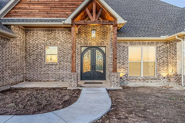 a view of a brick house with large windows