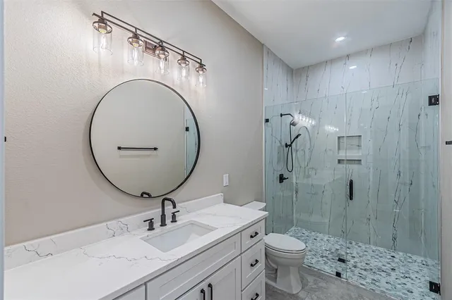 a bathroom with a sink a toilet and shower