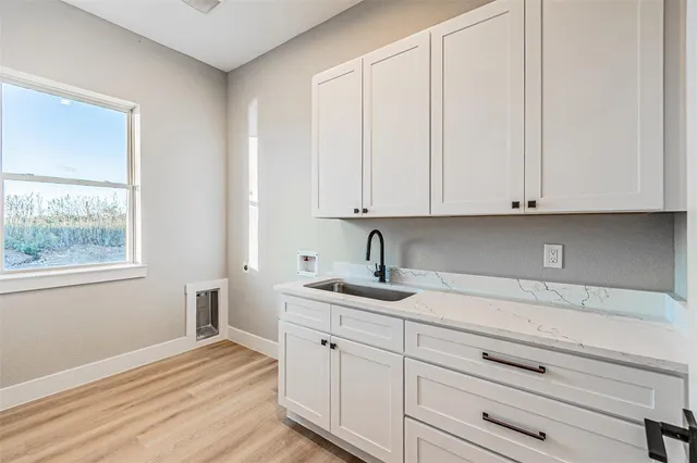 a kitchen with granite countertop white cabinets and sink