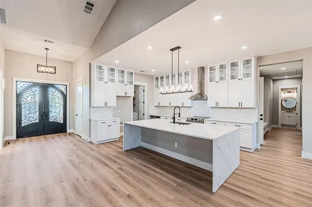 a large kitchen with cabinets wooden floor and stainless steel appliances