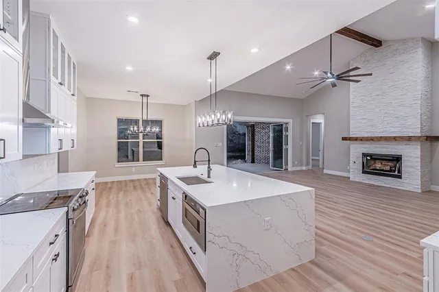 a large kitchen with stainless steel appliances granite countertop a sink dishwasher a stove and a oven with a large window