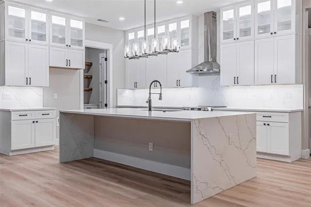 a kitchen with kitchen island granite countertop a sink cabinets and stainless steel appliances