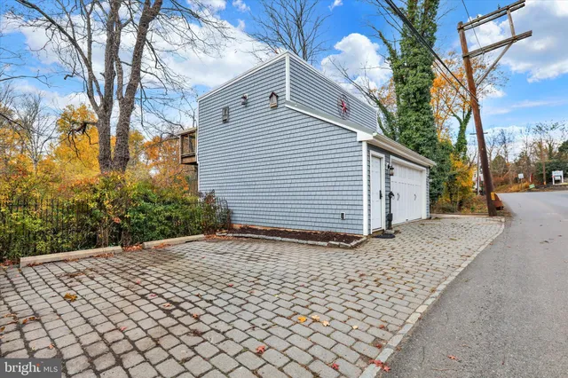 a backyard of a house with table and chairs under an umbrella