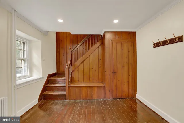 a view of an empty room with glass door and wooden floor