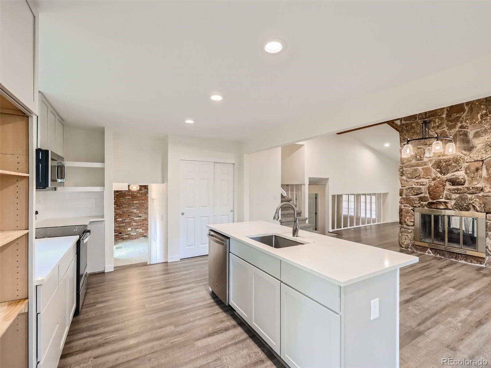 6124 Powell Road Parker, CO 80134 - Photo 12 of 50 a kitchen that has a lot of cabinets a sink and wooden floor