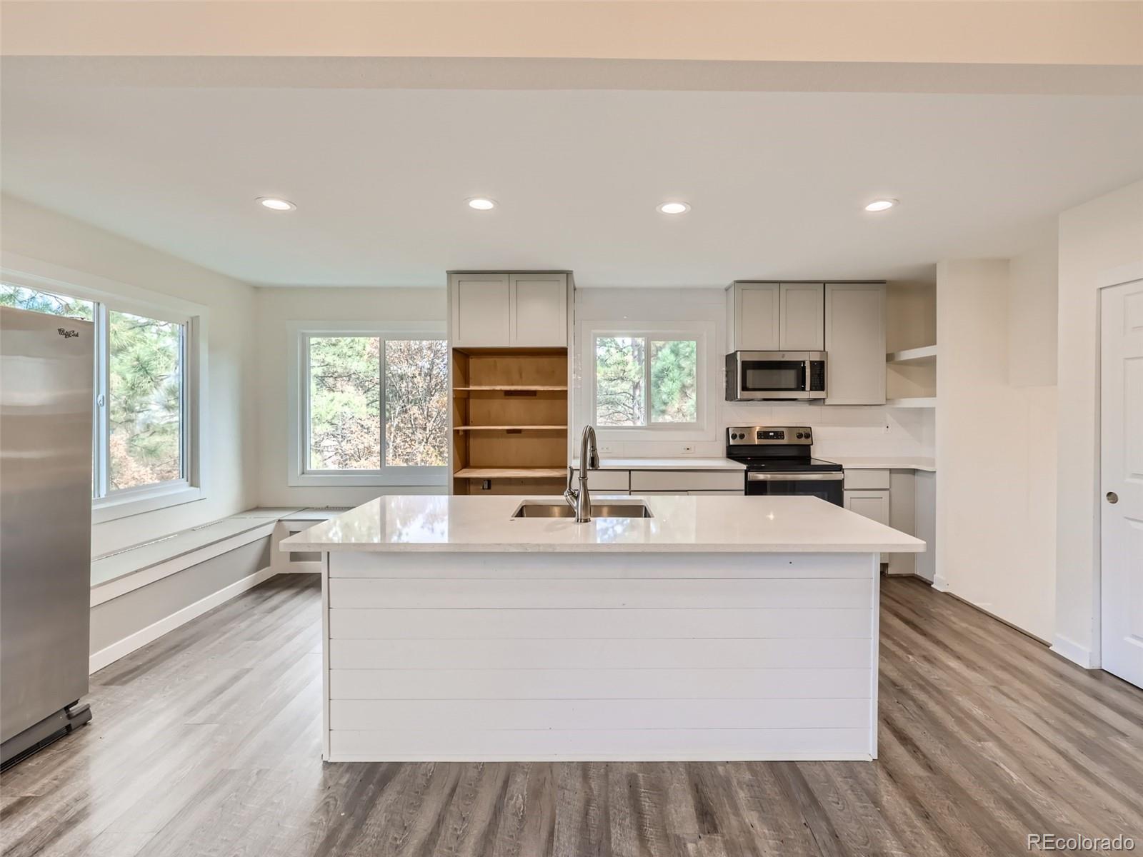 6124 Powell Road Parker, CO 80134 - Photo 14 of 50 a large kitchen with kitchen island a large counter top space a center island stainless steel appliances a large window and a counter top space
