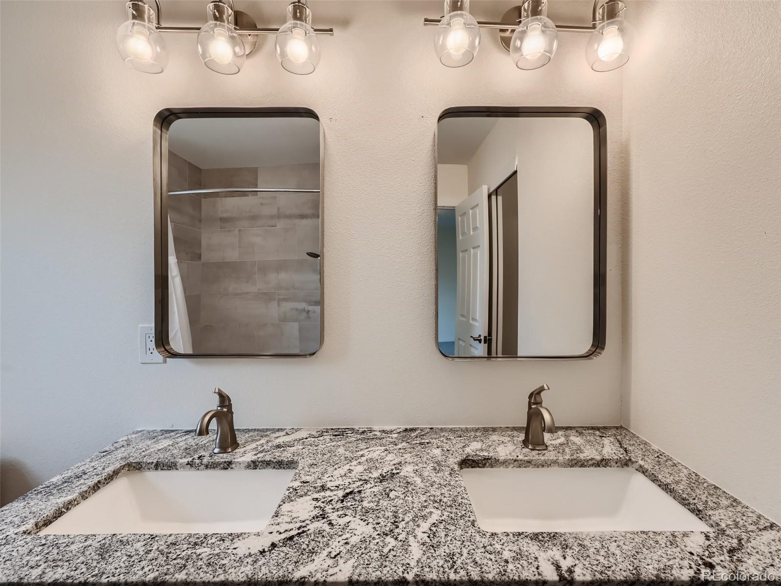 6124 Powell Road Parker, CO 80134 - Photo 24 of 50 a bathroom with double vanity sinks and a mirror