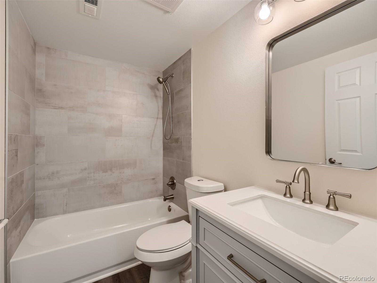 6124 Powell Road Parker, CO 80134 - Photo 29 of 50 a bathroom with a granite countertop sink toilet mirror and bathtub
