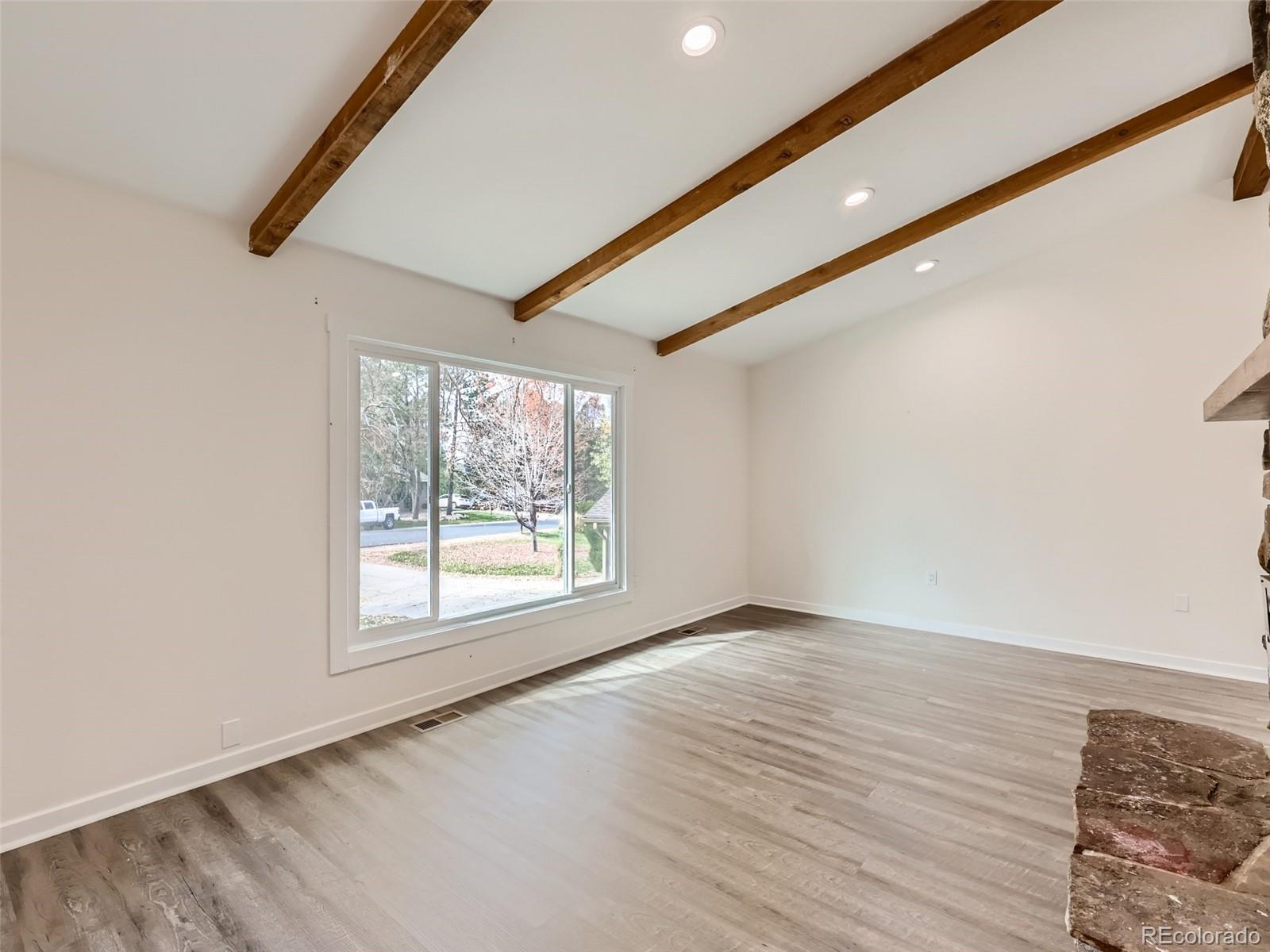 6124 Powell Road Parker, CO 80134 - Photo 6 of 50 an empty room with wooden floor and windows