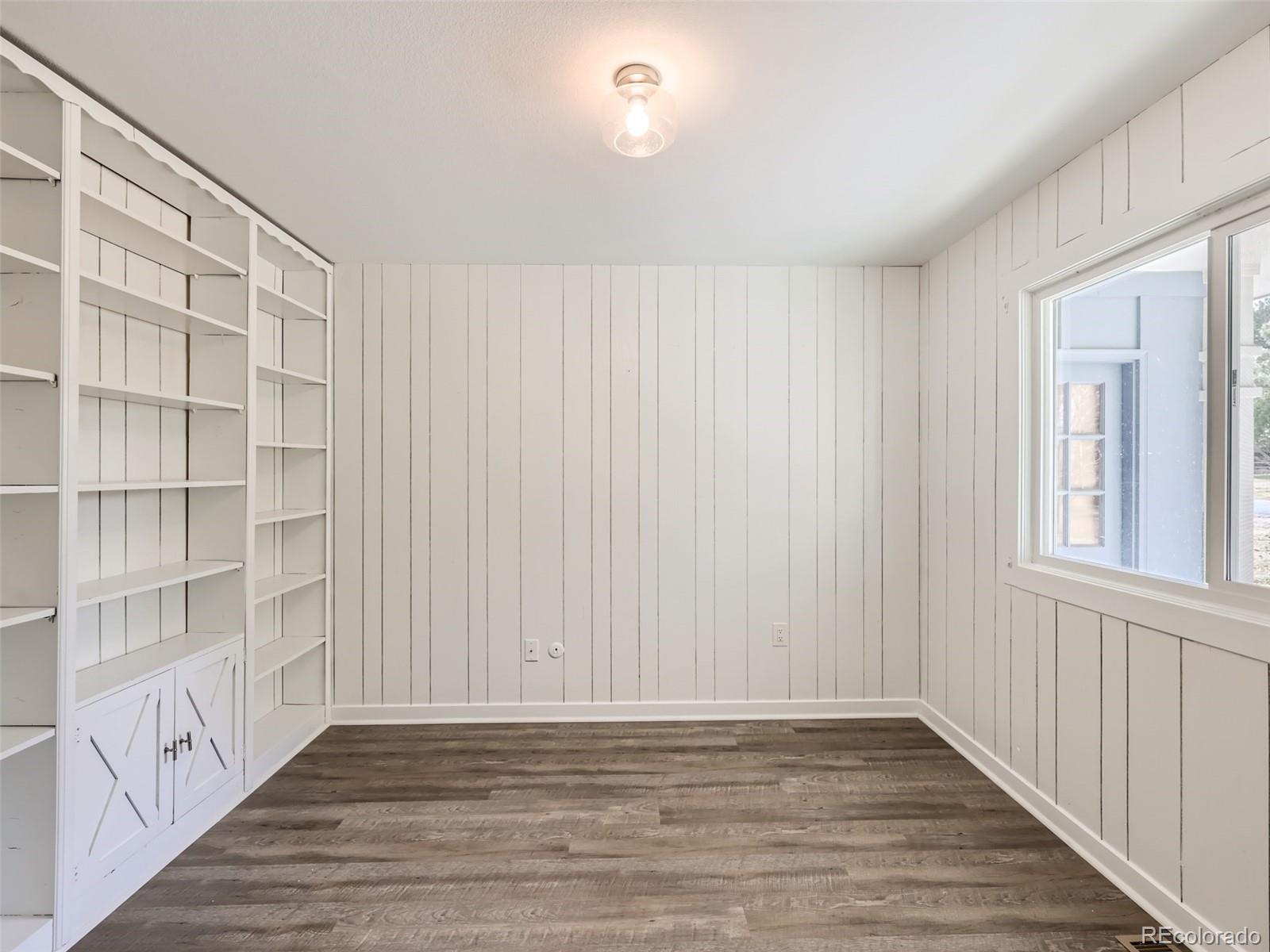 6124 Powell Road Parker, CO 80134 - Photo 9 of 50 a view of an empty room with wooden floor and a window