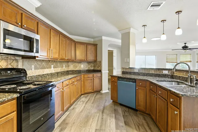 a kitchen with stainless steel appliances granite countertop a stove a sink and a microwave