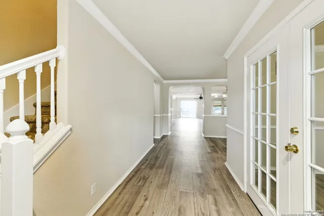 a view of a hallway with wooden floor and staircase
