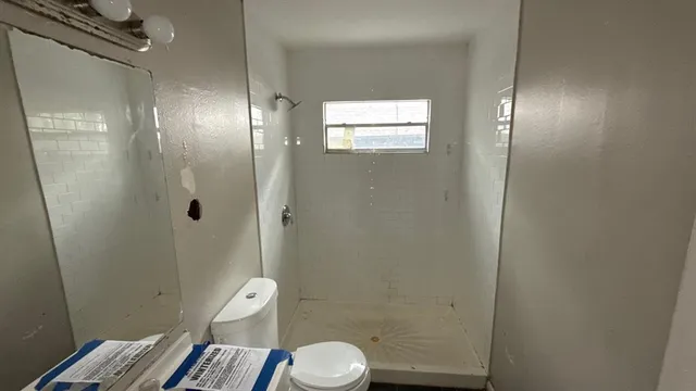 a bathroom with a toilet and a shower