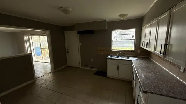 a view of an empty room with a kitchen