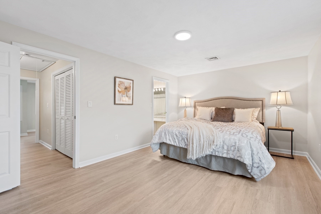 79 Patrick Road, Unit 79 Tewksbury, MA 01876 - Photo 11 of 18 a bedroom with a bed and wooden floor