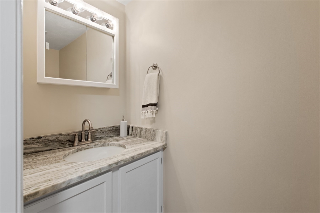 79 Patrick Road, Unit 79 Tewksbury, MA 01876 - Photo 14 of 18 a bathroom with a granite countertop sink and a mirror
