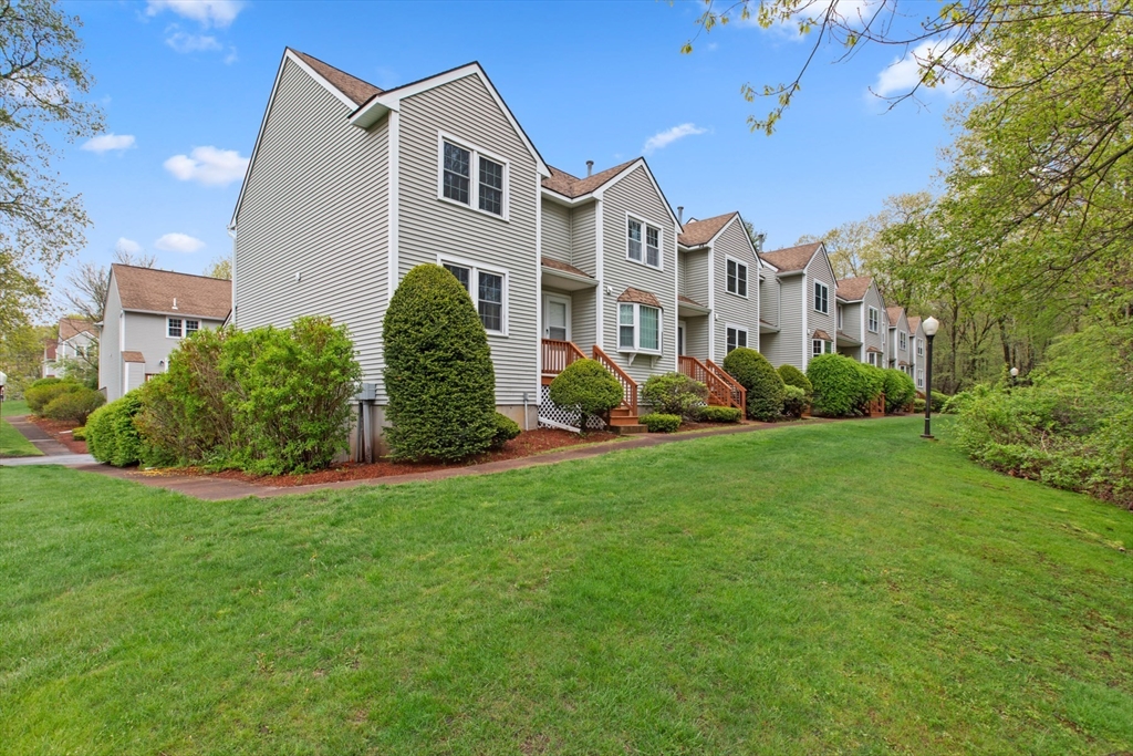 79 Patrick Road, Unit 79 Tewksbury, MA 01876 - Photo 2 of 18 a front view of a house with a yard