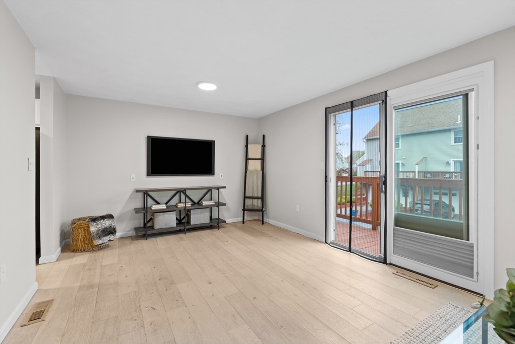 79 Patrick Road, Unit 79 Tewksbury, MA 01876 - Photo 6 of 18 a room with furniture and flat screen tv