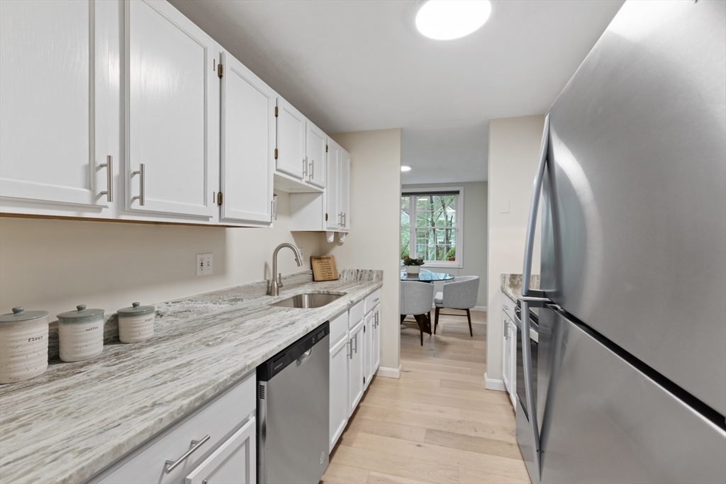 79 Patrick Road, Unit 79 Tewksbury, MA 01876 - Photo 7 of 18 a kitchen with stainless steel appliances granite countertop a sink stove and refrigerator
