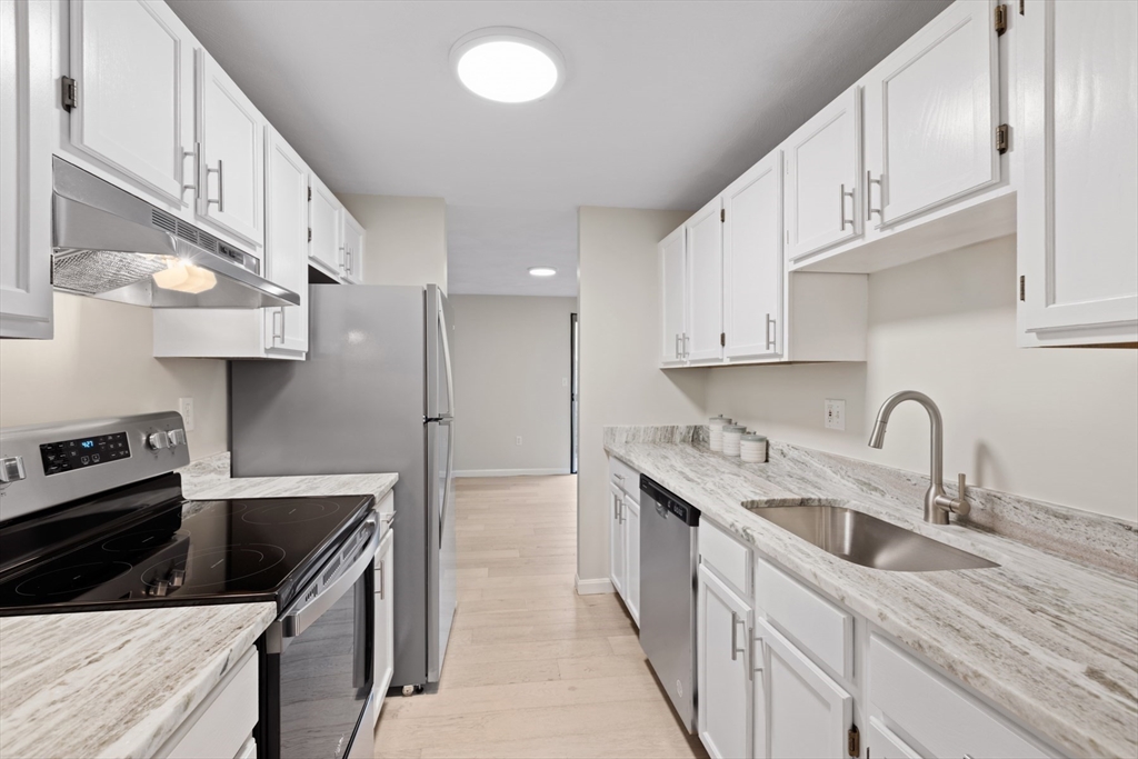 79 Patrick Road, Unit 79 Tewksbury, MA 01876 - Photo 8 of 18 a kitchen with stainless steel appliances granite countertop a sink stove and refrigerator