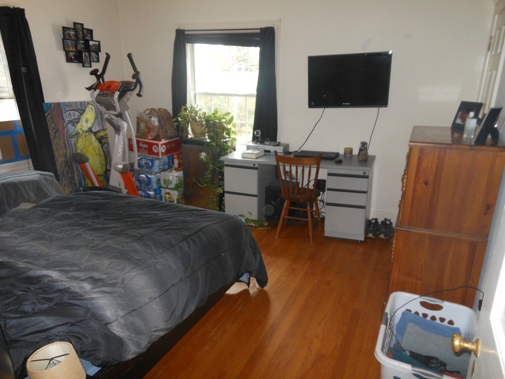 18 Pierce Street Malden, MA 02148 - Photo 12 of 29 a bedroom with a bed a flat screen tv and a bookshelf