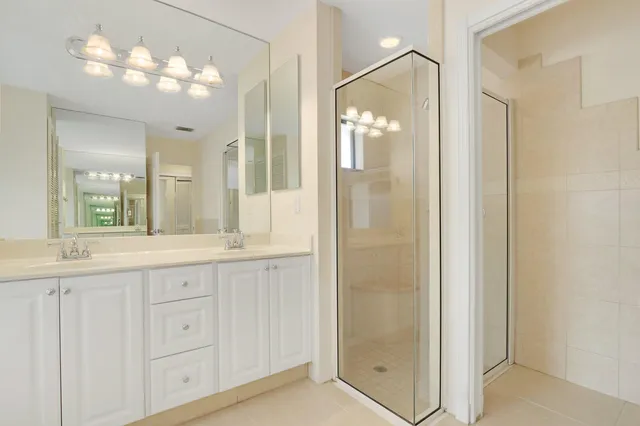 a bathroom with a granite countertop sink a mirror and a shower