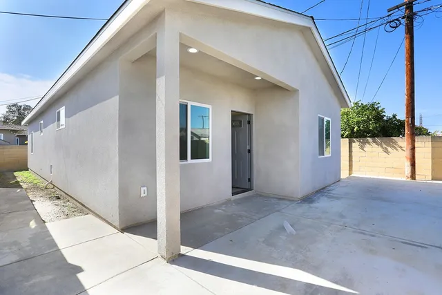 a kitchen with a sink dishwasher a stove and white cabinets with wooden floor
