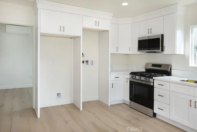 a kitchen with stainless steel appliances a stove a sink and a microwave