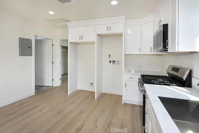 a bathroom with a toilet sink vanity granite and shower