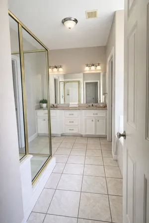 a bathroom with a granite countertop sink mirror and shower