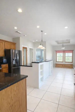 a large kitchen with stainless steel appliances kitchen island granite countertop a large counter top and a stove