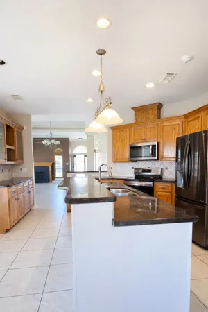 a kitchen with stainless steel appliances granite countertop a sink refrigerator and cabinets