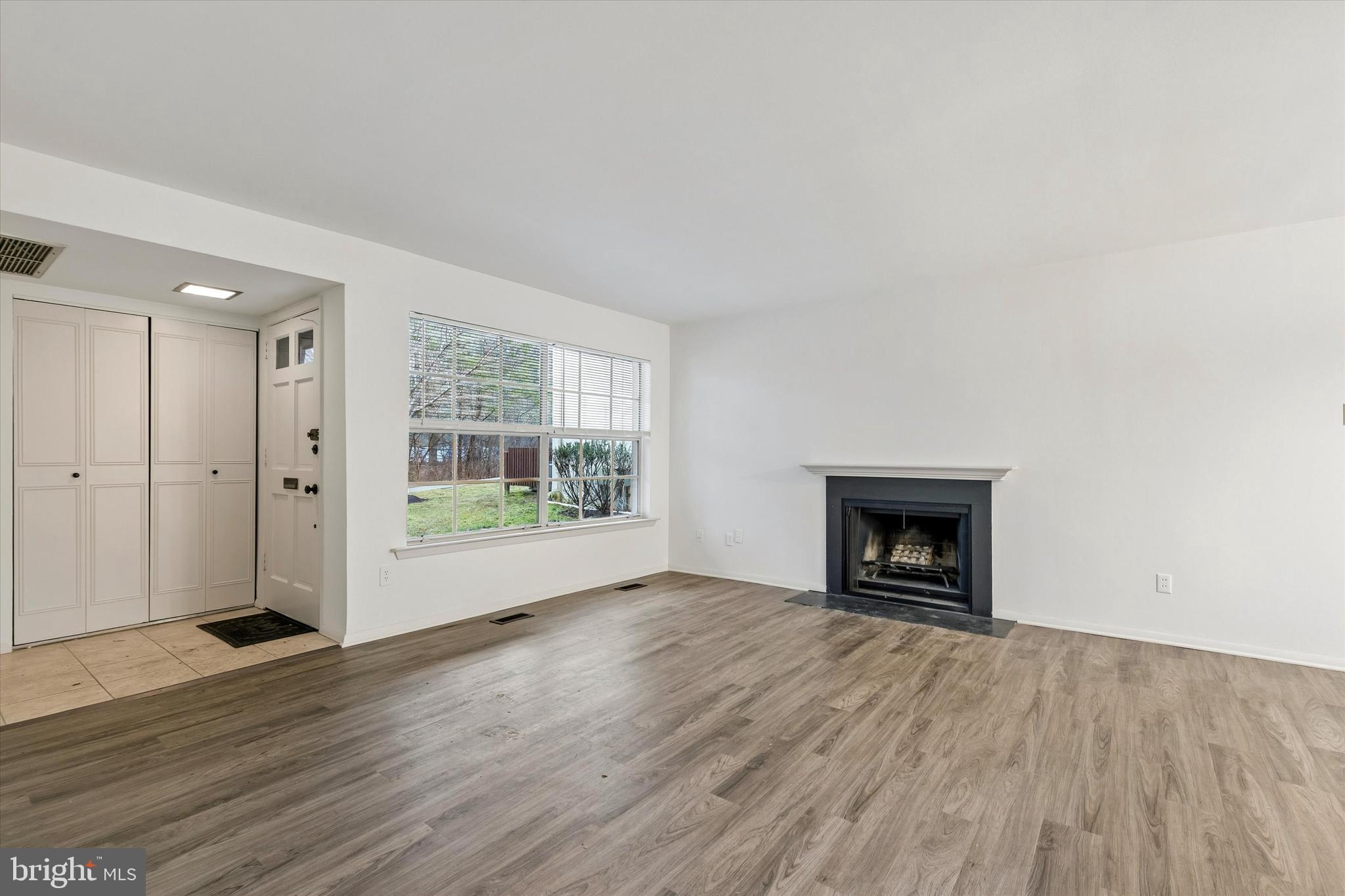 521 Old Forge Crossing Wayne, PA 19087 - Photo 3 of 15 an empty room with wooden floor a fireplace and windows