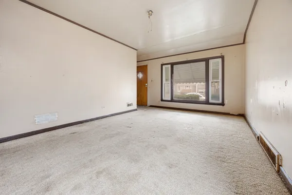 an empty room with windows and ceiling fan