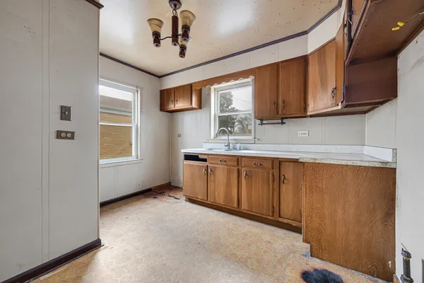 a kitchen with stainless steel appliances granite countertop a sink window and cabinets