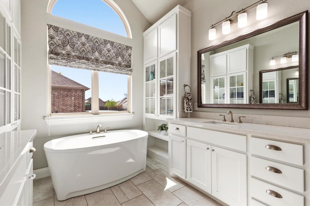 1108 Granada Drive Allen, TX 75013 - Photo 26 of 40 a bathroom with a bathtub a sink and a window