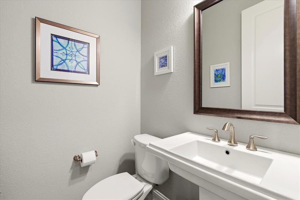 1108 Granada Drive Allen, TX 75013 - Photo 32 of 40 a bathroom with a toilet a sink and mirror