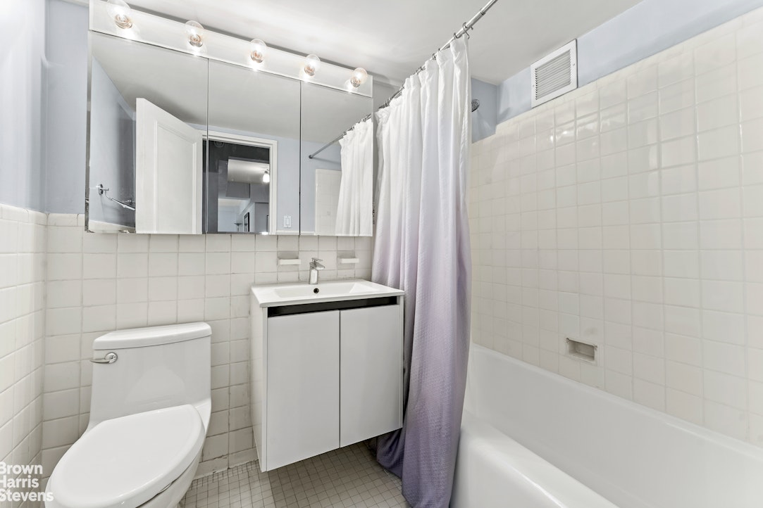 11 Riverside Drive, Unit 11AW Manhattan, NY 10023 - Photo 6 of 13 a bathroom with a sink a toilet and shower