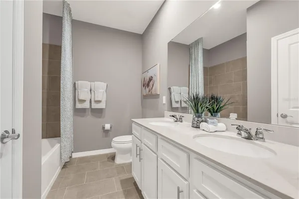 a bathroom with a sink a toilet and a large mirror