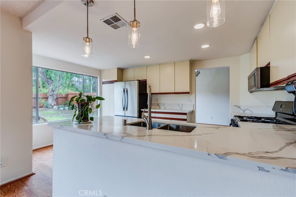 5349 Gooseberry Way Oceanside, CA 92057 - Photo 13 of 35 a kitchen with stainless steel appliances a refrigerator a sink a stove and cabinets