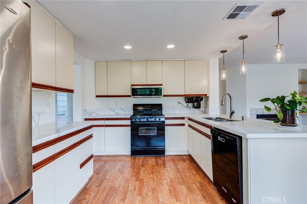 5349 Gooseberry Way Oceanside, CA 92057 - Photo 10 of 35 a kitchen with granite countertop stainless steel appliances and wooden cabinets