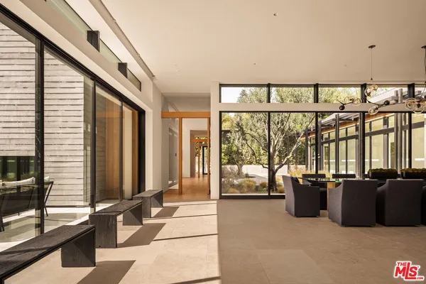 a living room with furniture large windows and flat screen tv
