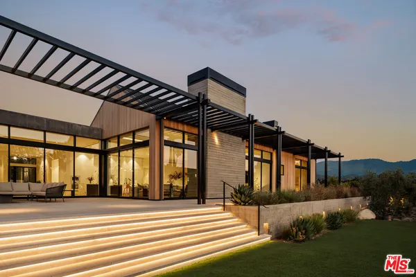 a view of a house with backyard and sitting area